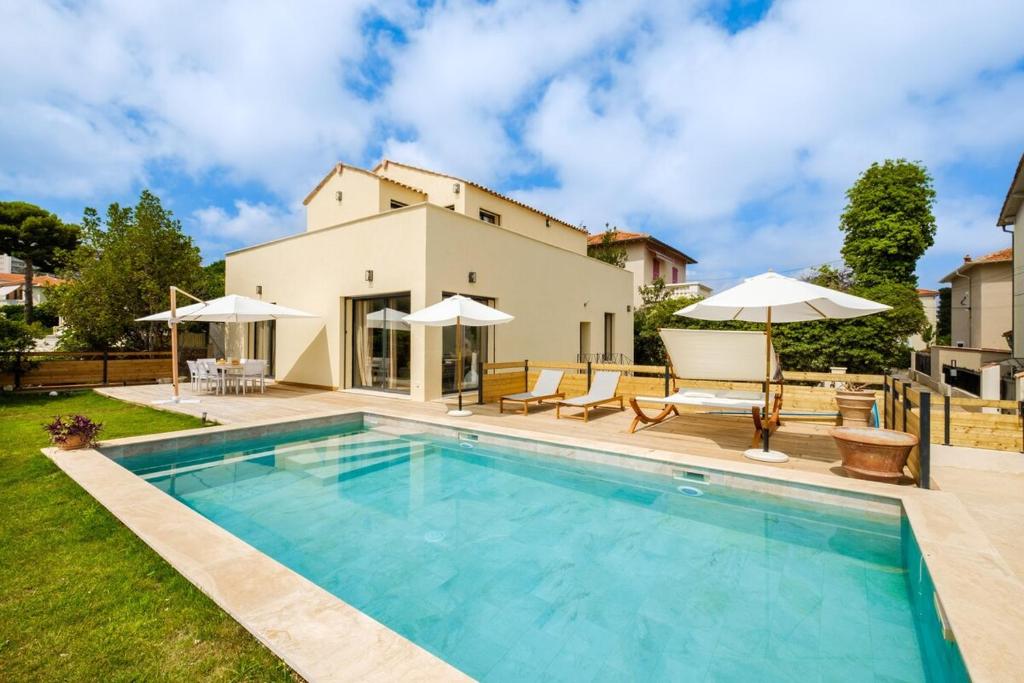 a villa with a swimming pool in front of a house at Sublime villa - centre Nice 8P in Nice
