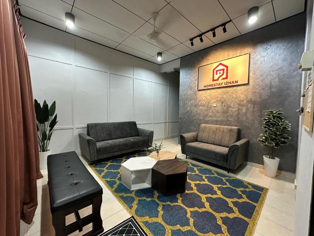 a lobby with two chairs and a table and a sign at HOMESTAY IZHAN BANDAR KUALA TERENGGANU in Kuala Terengganu