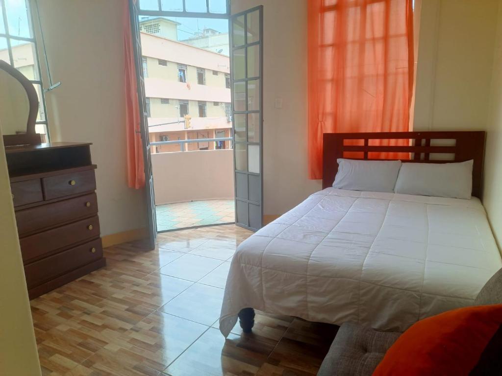 a bedroom with a bed and a large window at Hotel City Central Guayaquil in Guayaquil