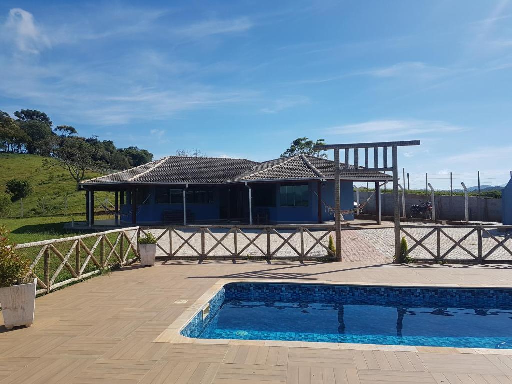 ein Haus mit einem Pool und einem Pavillon in der Unterkunft Casa Nas Montanhas em Camanducaia Sul de Minas in Camanducaia