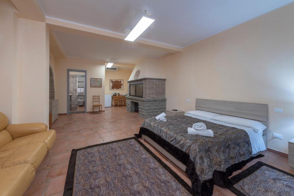 ein großes Schlafzimmer mit einem Bett und einem Sofa in der Unterkunft AIR B&B PLEASANT MOMENTS in Bolsena