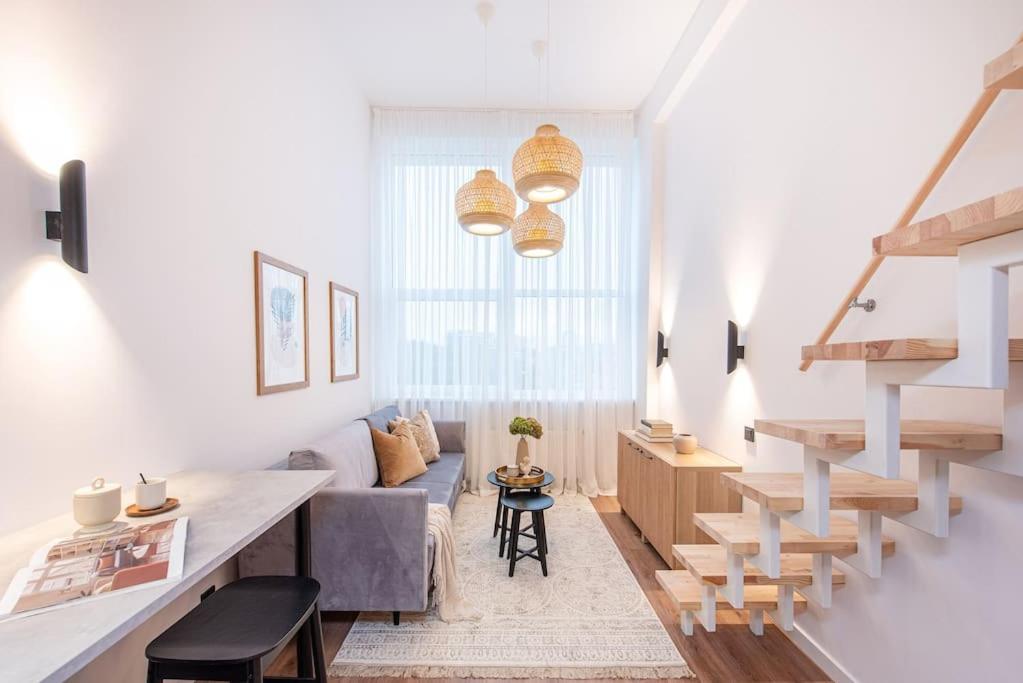 a white living room with a couch and a table at City Sky Loft in Vilnius in Vilnius