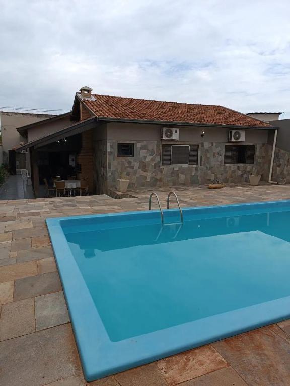 a blue swimming pool in front of a house at Casa com ótima localização e lazer espetacular. in Sao Jose do Rio Preto