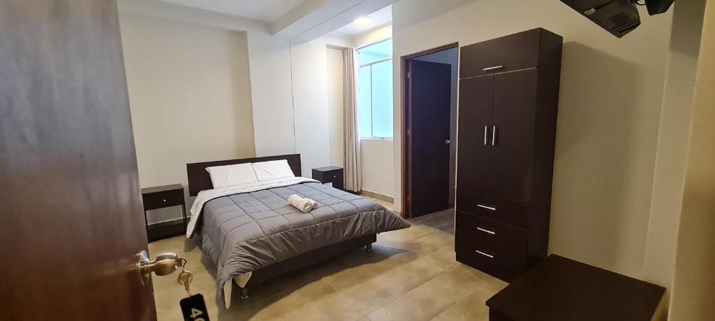 Dormitorio pequeño con cama y vestidor en Hospedaje Mónaco, en San Vicente de Cañete