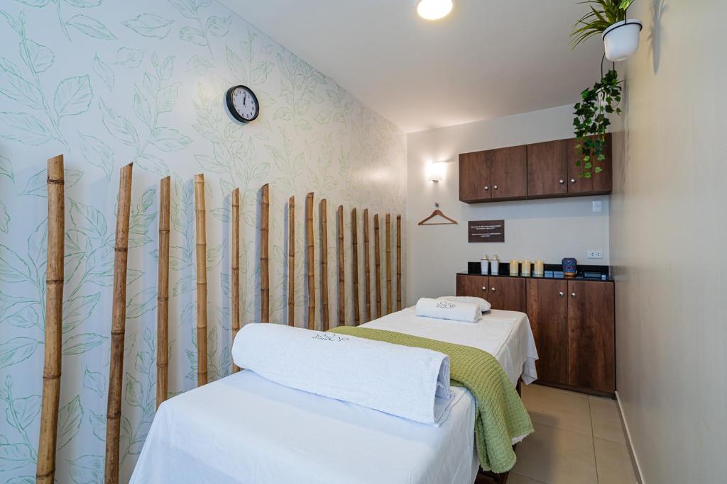Zimmer mit 2 Betten und einer Wand mit einer Uhr in der Unterkunft Casa Andina Standard Trujillo Plaza in Trujillo