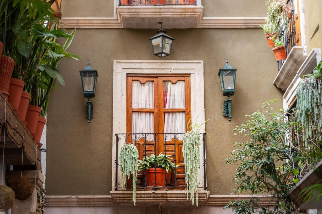 a building with a window with a plant on a balcony at Hotel Rincon de Josefa in Pátzcuaro