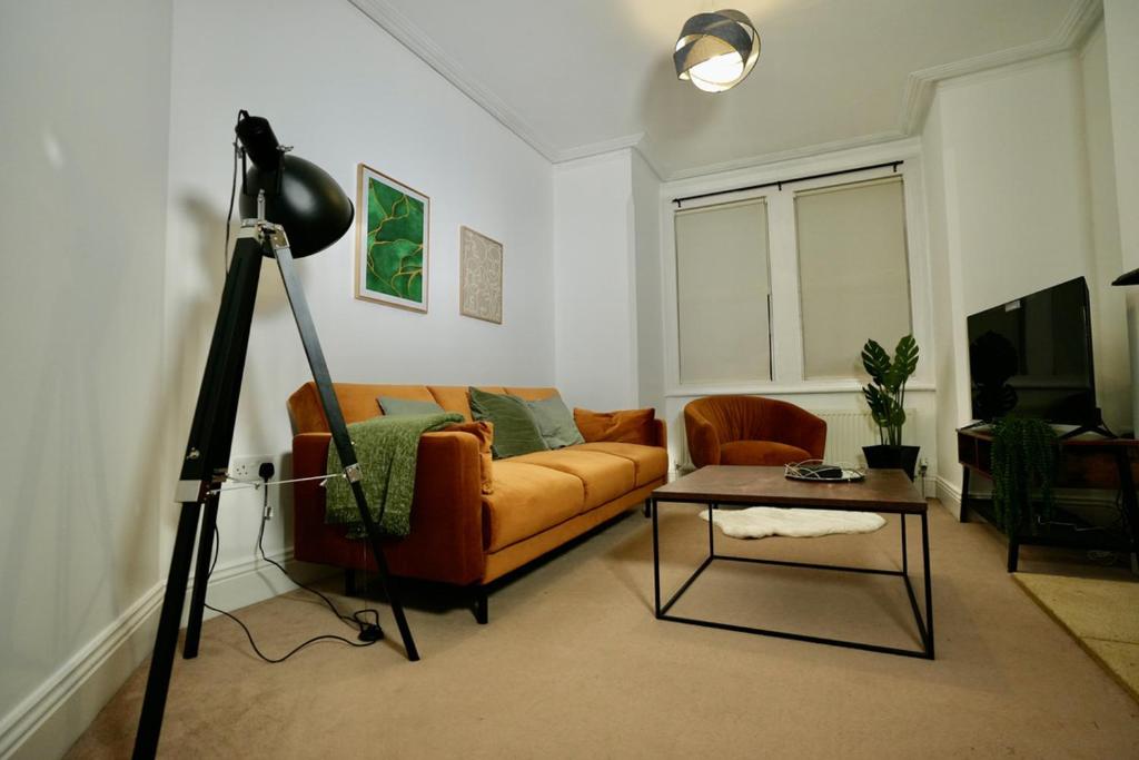 a living room with a couch and a table at Spacious two-bedrooms house, private parking, contractors, relocators in Oxford