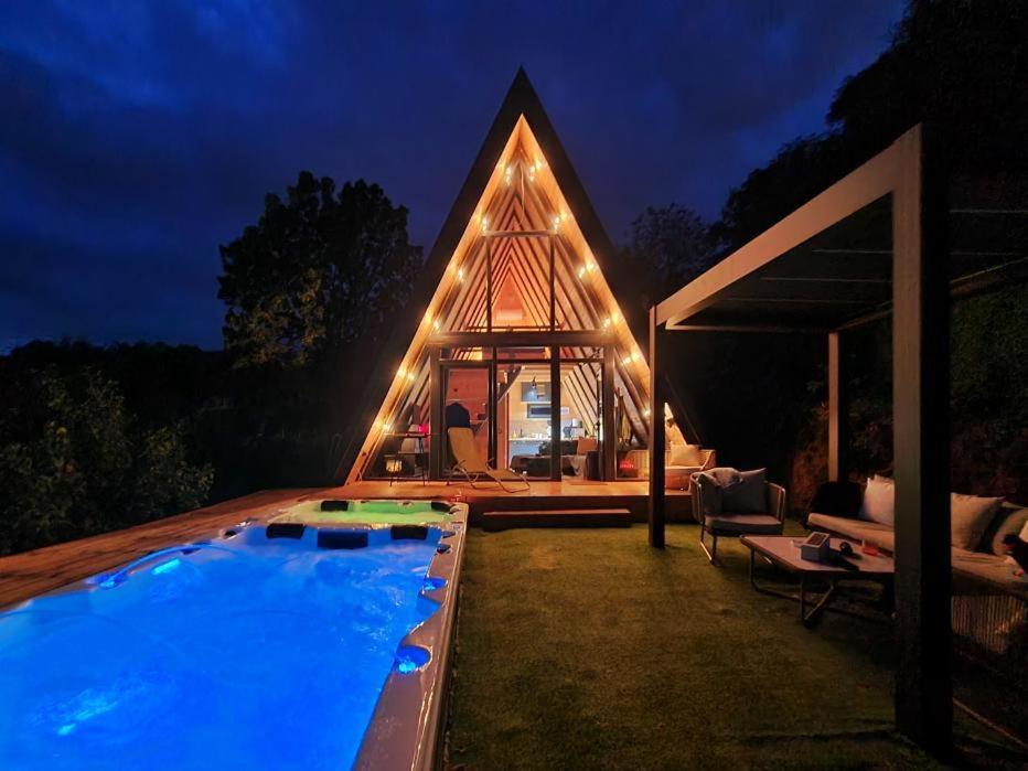 una casa con piscina en el patio por la noche en Mountain spa Yin&Yang, en Ledinci