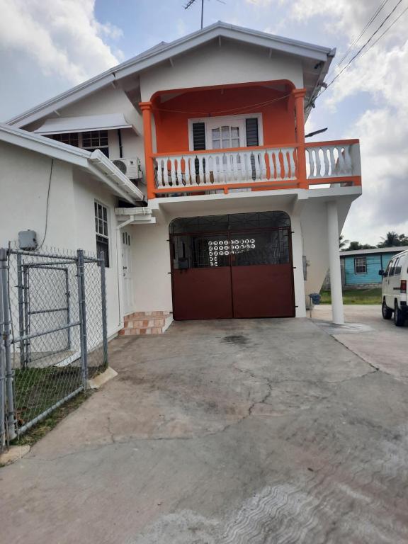 ein orangefarbenes und weißes Haus mit einer Garage in der Unterkunft Joyville in Bridgetown