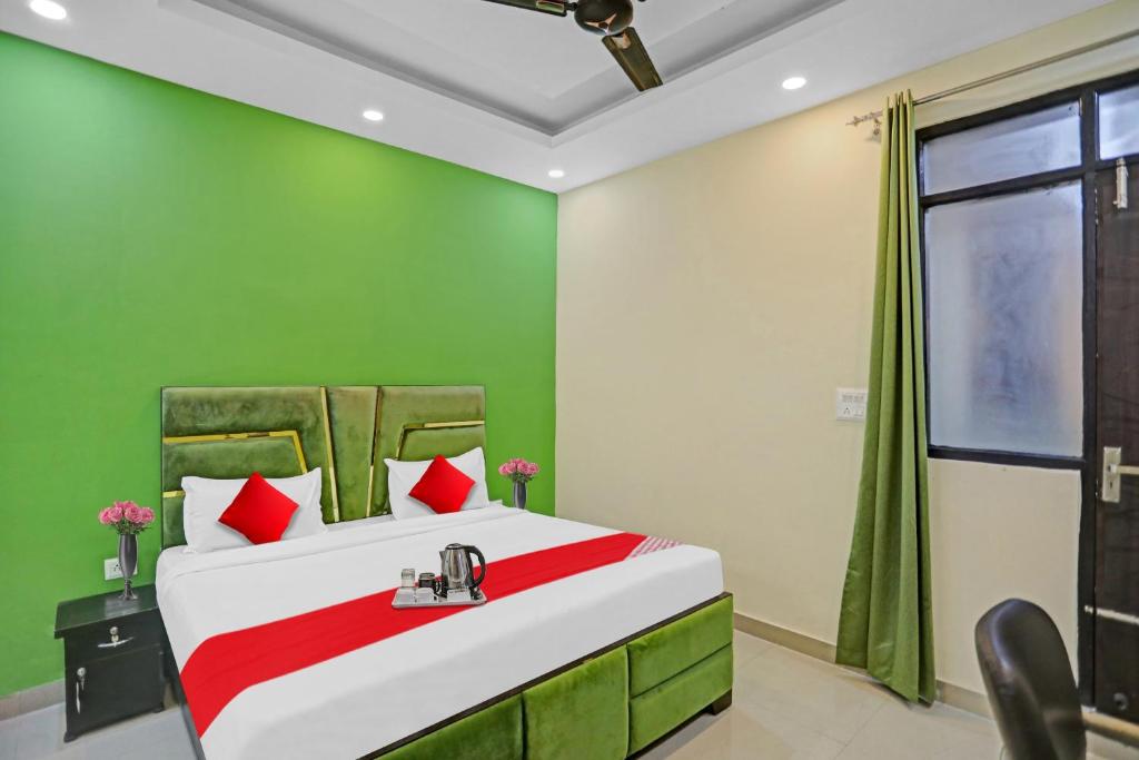 um quarto com uma cama grande e paredes verdes em Flagship Grand Imperial Near Worlds Of Wonder em Kālkāji Devi