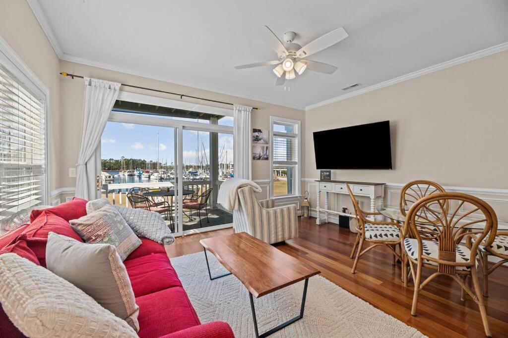 uma sala de estar com um sofá vermelho e uma mesa em Marina Vista Retreat em New Bern