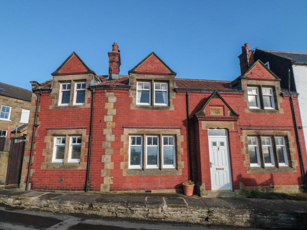 an old red brick house with a white door at Dale View in Whitby