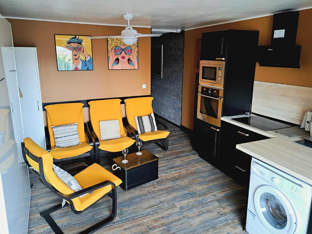 eine Küche mit orangefarbenen Stühlen, einer Waschmaschine und einem Trockner in der Unterkunft Appartement avec parking Cap d'Agde, La Falaise in Cap d'Agde
