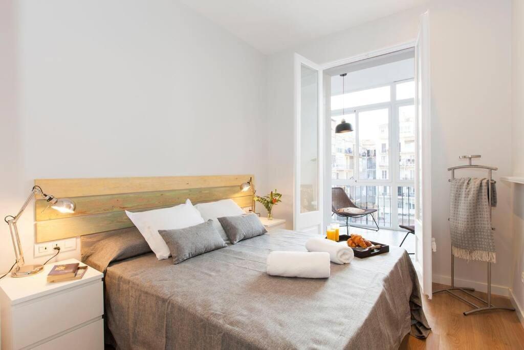 a bedroom with a large bed with a large window at Beautiful 4bd 4ba apartment in Eixample District in Barcelona