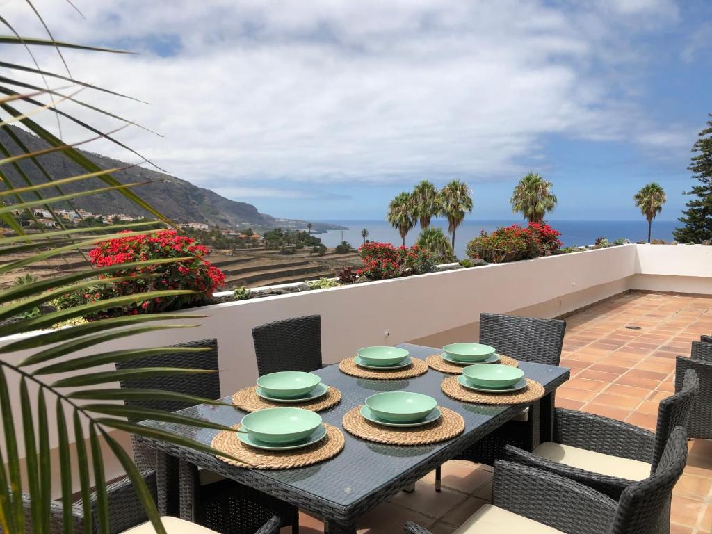 uma mesa e cadeiras numa varanda com vista para o oceano em ATICO JAZMIN em Santa Cruz de Tenerife