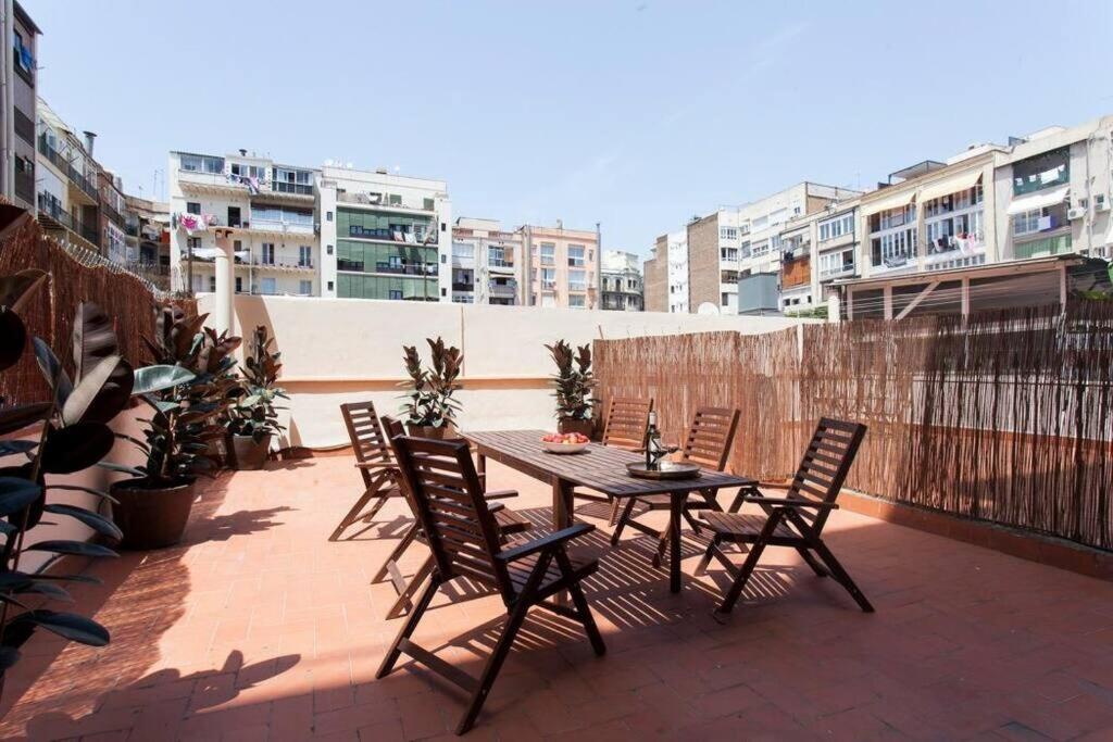 een patio met een tafel en stoelen op een dak bij Stylish and centric 2-bedroom apartment in Eixample &Terrace P2 in Barcelona