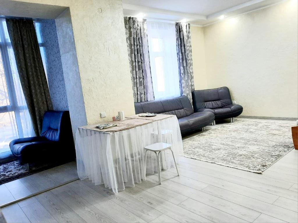 a living room with a table and a couch at Жк JanaAlem 57 in Kokshetau