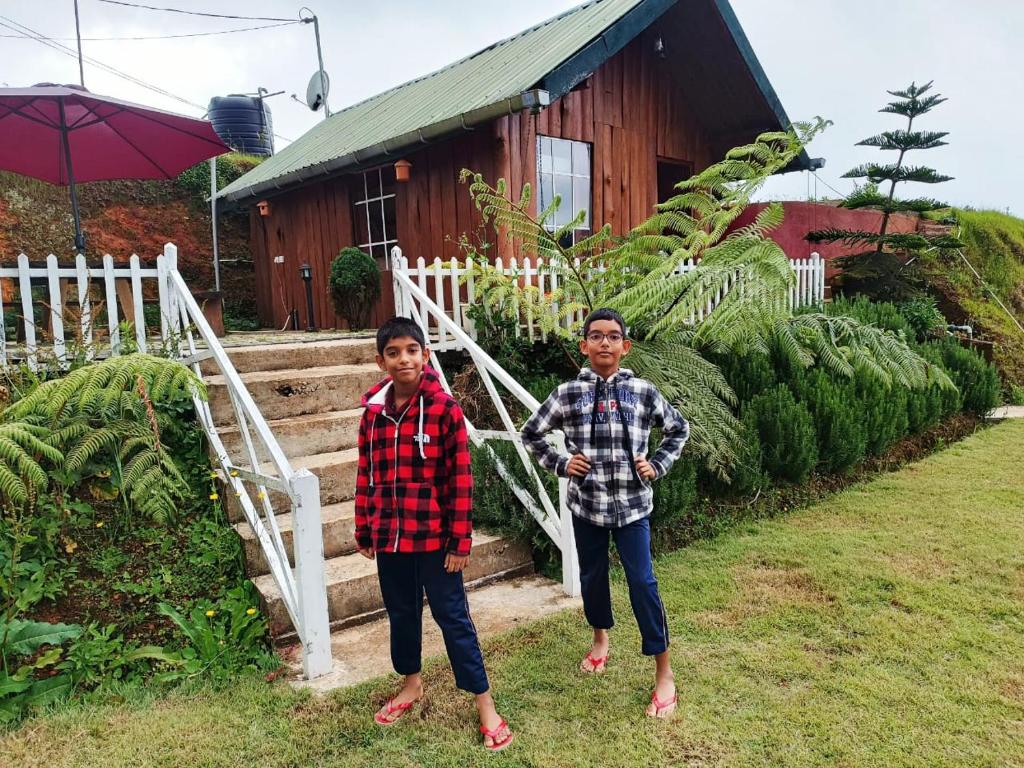 two young boys standing in front of a house at Charley's Heaven Ambewela in Ambawela