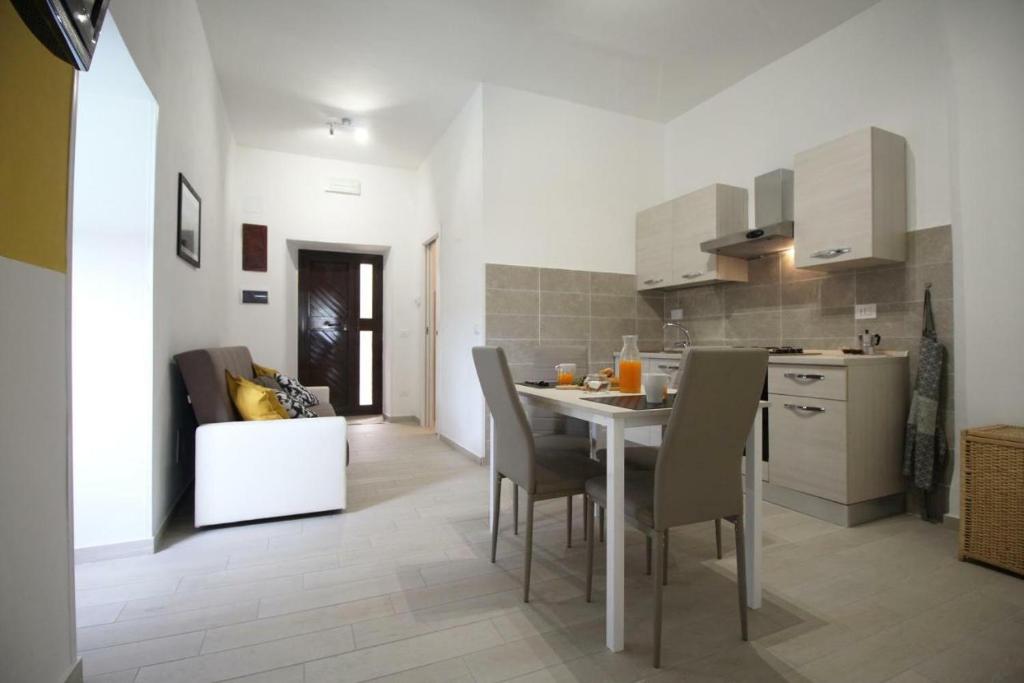 een keuken en eetkamer met een tafel en stoelen bij Casa vacanze Barbera in Sutri