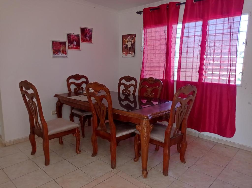 ein Esszimmer mit einem Holztisch und Stühlen in der Unterkunft Dormir in Boca Chica