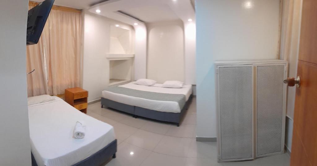 a small room with two beds and a mirror at AW Connect Airport in Bogotá