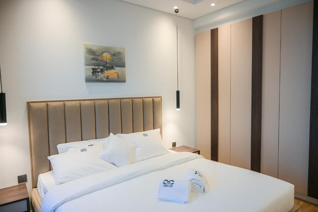 a bedroom with a large bed with white sheets at Diamond Jumeirah Garden City 1BR Apt in Dubai