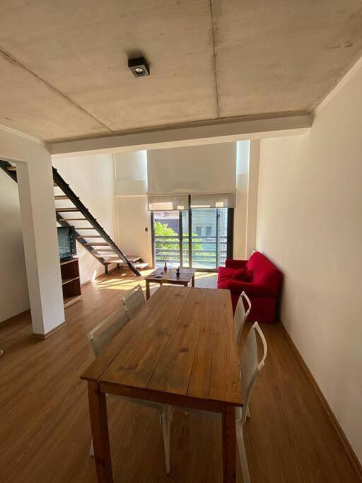 sala de estar con mesa de madera y sillas en Duplex San Martín en Lobos