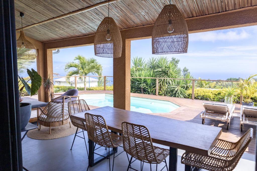 - une salle à manger avec une table, des chaises et une piscine dans l'établissement Villa cactus avec piscine et vue mer, à La Saline