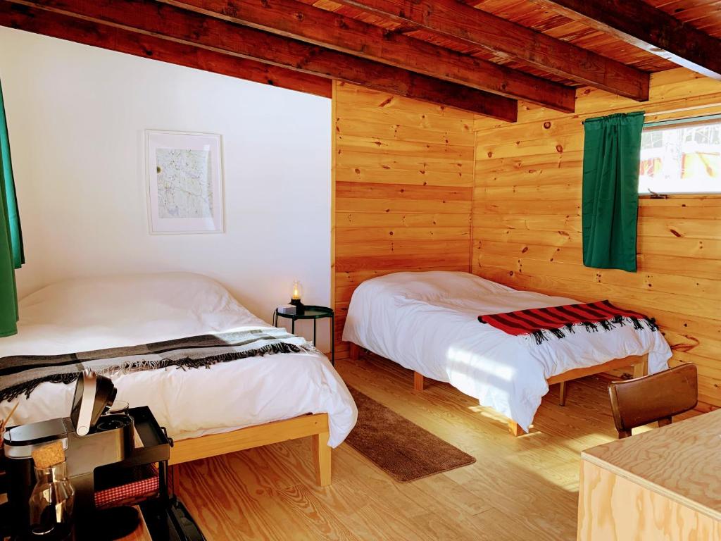 1 dormitorio con 2 camas en una cabaña de madera en The Lorca Adirondacks Motel en Indian Lake