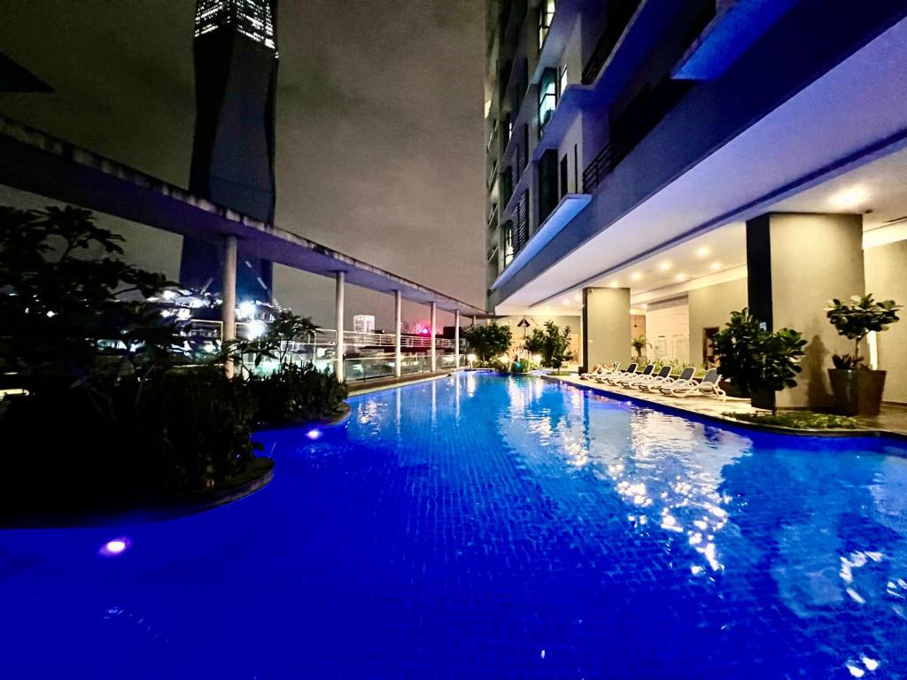 吉隆坡的住宿－Casa Residency Apartment，一座大型蓝色游泳池,晚上在大楼里