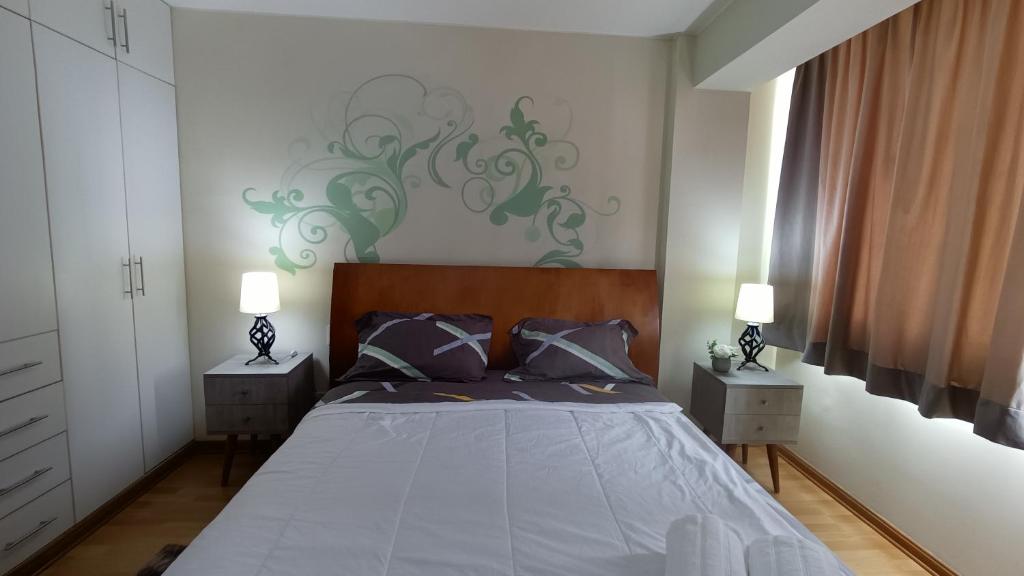 1 dormitorio con 1 cama con 2 mesitas de noche y 2 lámparas en Miraflores View, en Lima