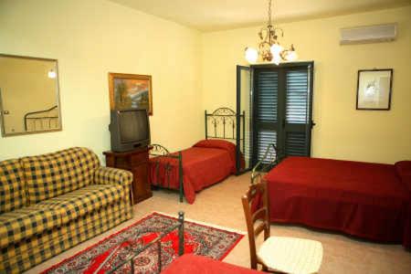 a living room with a couch and a bed and a tv at B&B Villa el Tango in Villa San Giovanni