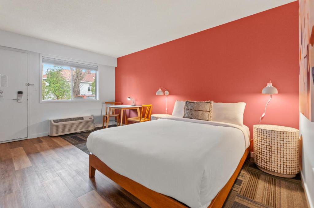 um quarto com uma cama grande e uma parede vermelha em Okanagan Lakefront Resort em Penticton
