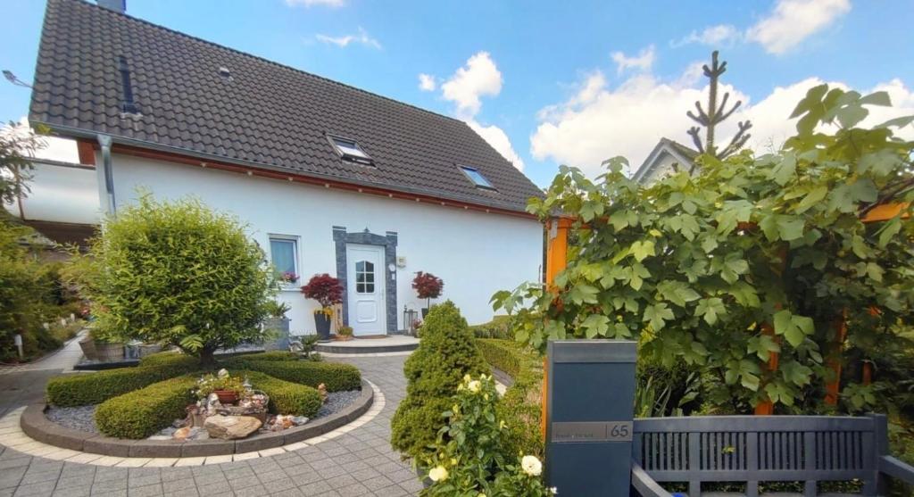 una casa blanca con un jardín delante de ella en Ferienwohnung Rosa - b48939, en Horn-Bad Meinberg