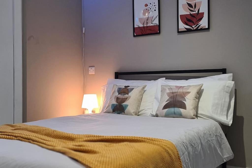 a bedroom with a bed with white sheets and pillows at Stylish & modern studio in Burnley in Burnley