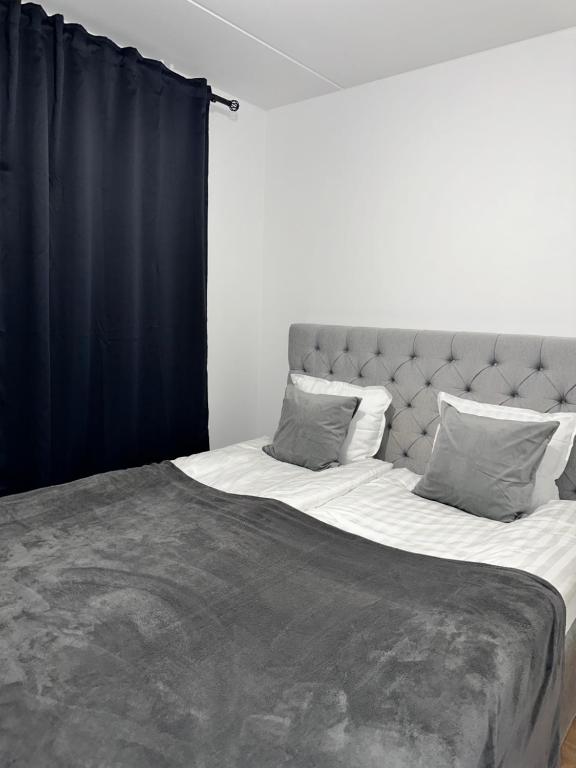a bedroom with a large bed with black curtains at Fresh Apartment in Stockholm