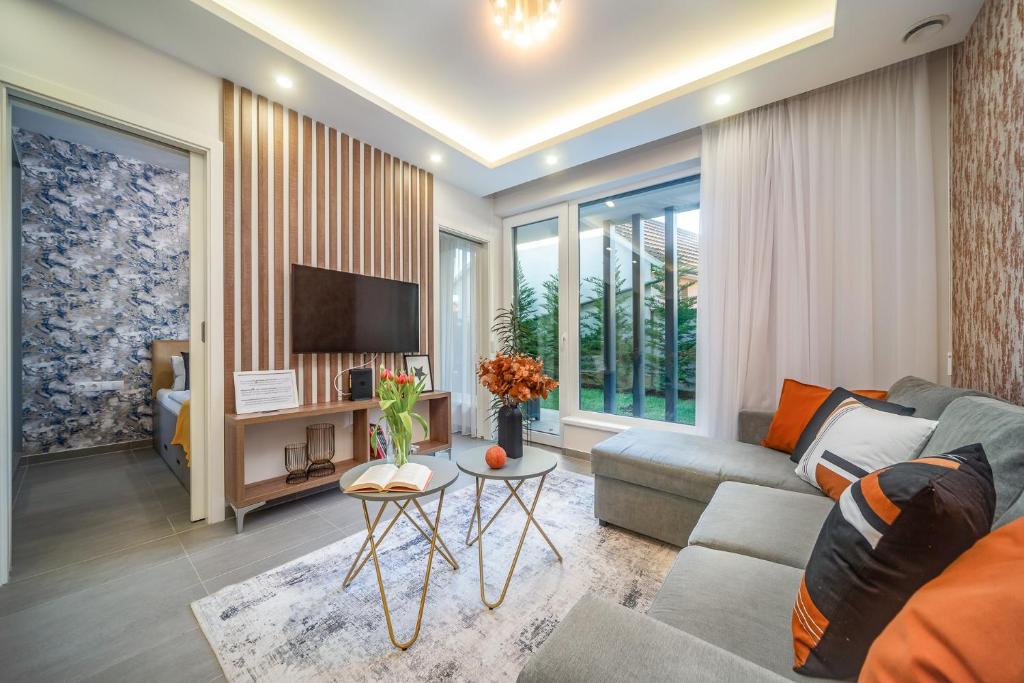 a living room with a couch and a tv at LaVida Deluxe villa Hajdúszoboszló in Hajdúszoboszló