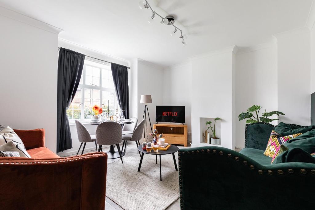 un soggiorno con divano e tavolo di Stylish & Spacious 3bed in Putney a Londra