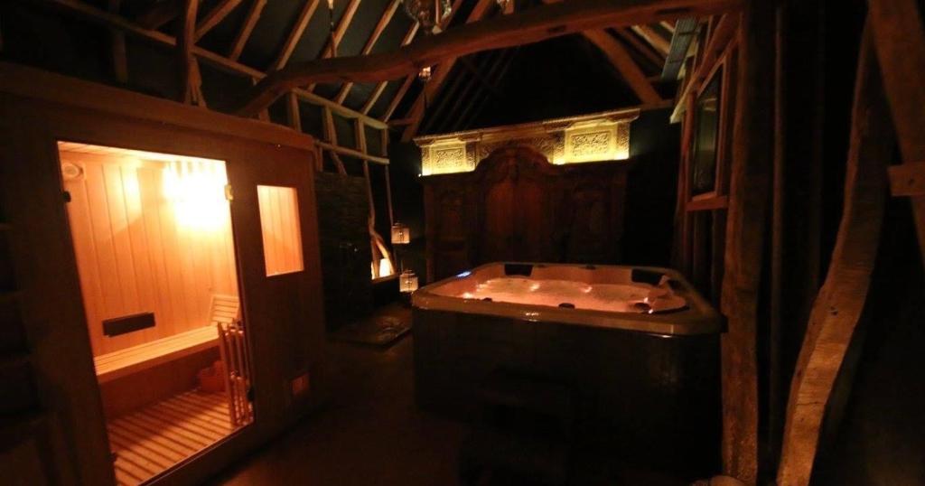 uma casa de banho com banheira num quarto em Gite de la Chapelle option SPA em Verchocq