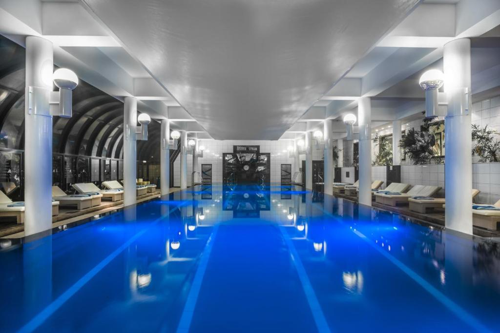 a swimming pool with blue water in a building at Amathus Beach Hotel Limassol in Limassol