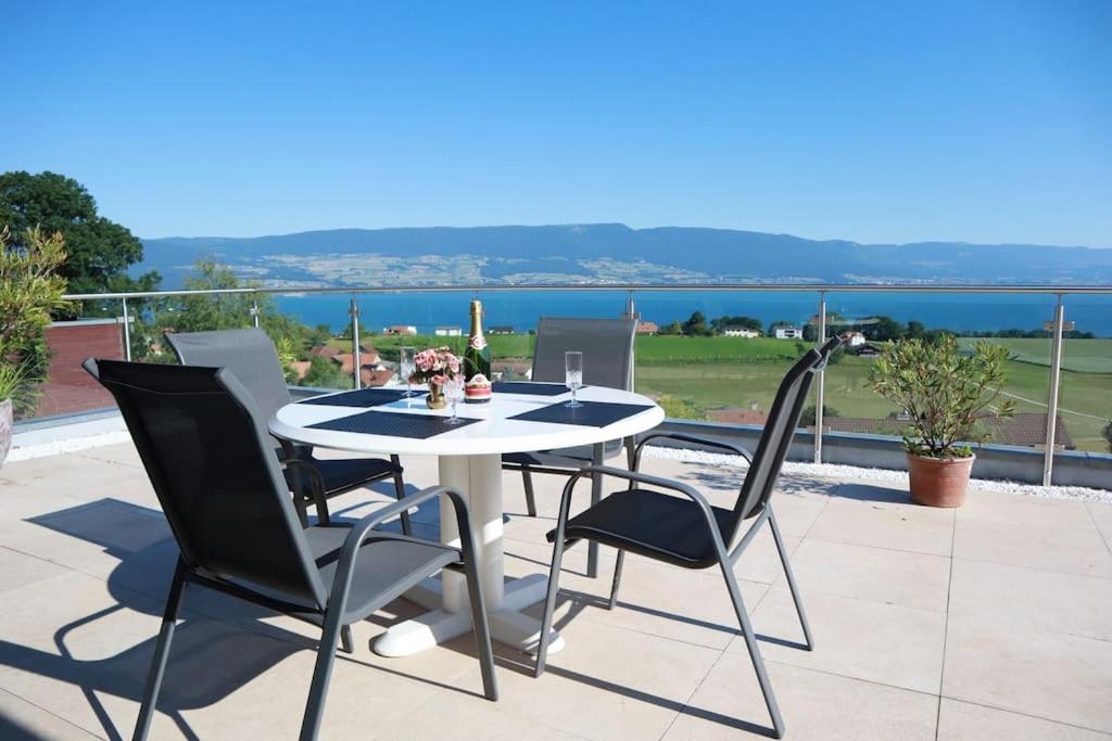 a table and chairs on a patio with a view of the water at Romantic Châlet with TOP Panorama in Châtillon