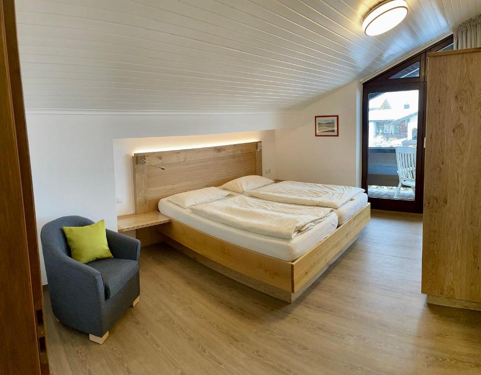 a bedroom with a large bed and a chair at Ferienwohnung Frauendorf in Schönau am Königssee