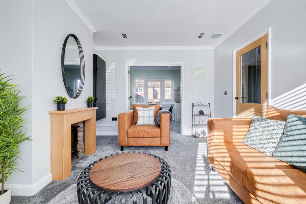 a living room with a couch and a table at Stylishly decorated 3 bed house presented by Our Home Short Stays comfortable beds with crisp linen and plenty of outdoor space to enjoy in Bedford