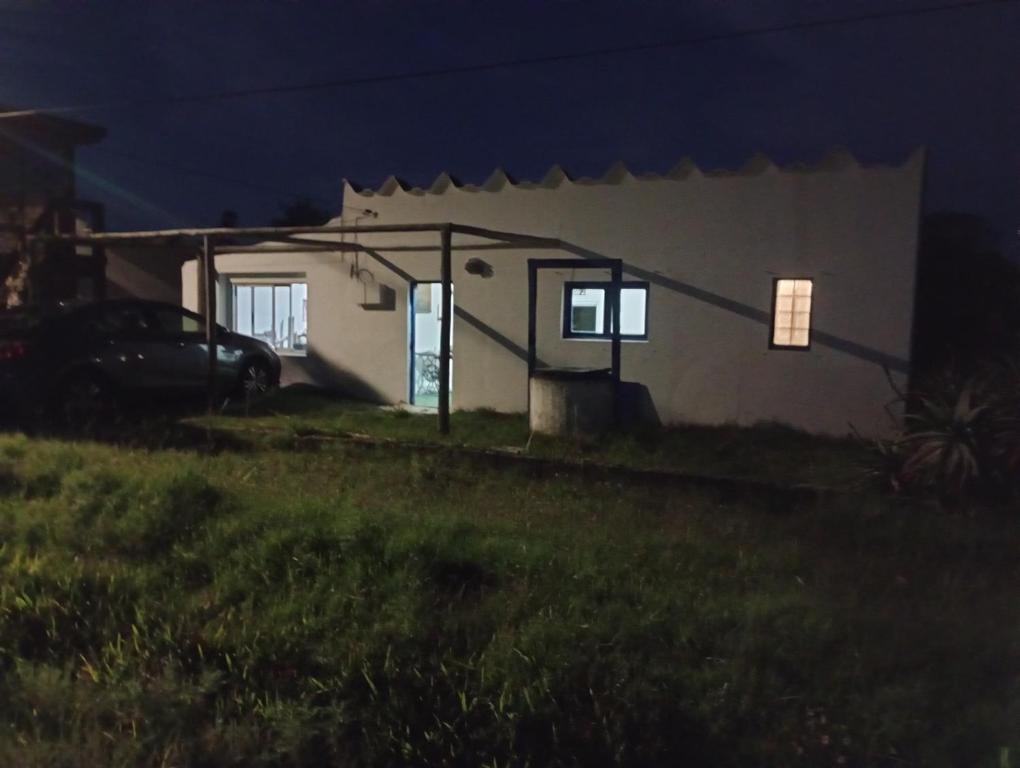 una pequeña casa por la noche con un coche aparcado fuera en Antoniopolis, en Rocha