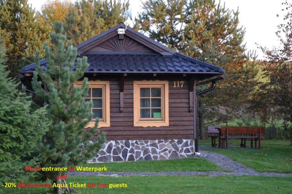 a small log cabin with a bench in a yard at Holiday Home Tatralandia in Liptovský Mikuláš