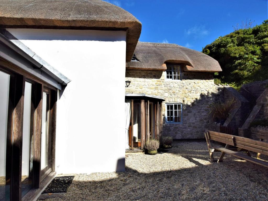 a stone building with a bench in front of it at 3 Bed in Lulworth Cove DC023 in West Lulworth