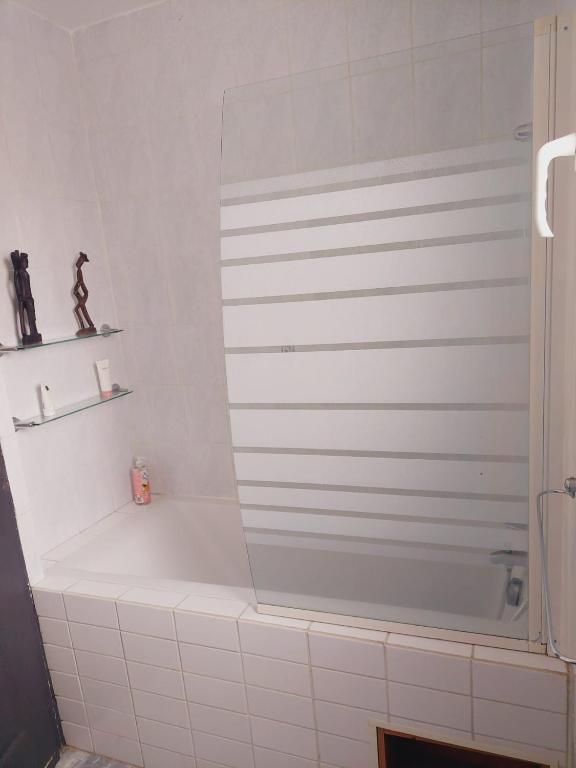 a white bath tub in a bathroom with a shelf at Charmante villa équipée, piscine in Le Soler