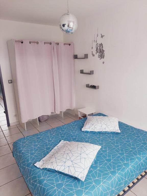 a bedroom with a blue bed with two pillows at Charmante villa équipée, piscine in Le Soler