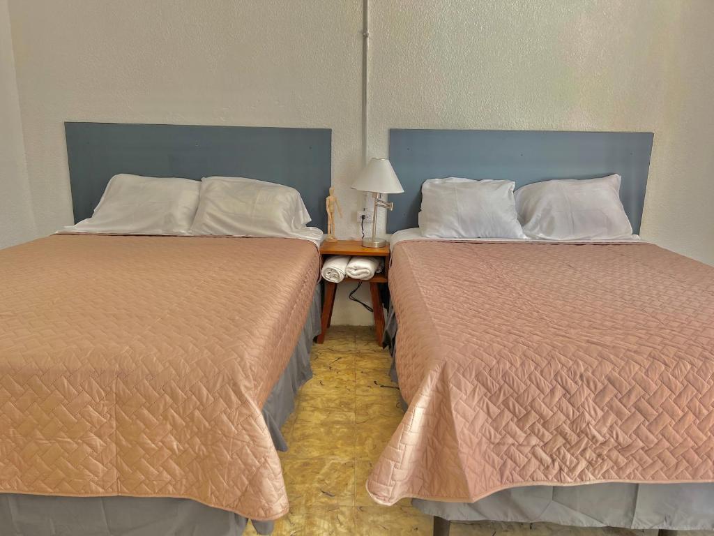 dos camas sentadas una al lado de la otra en una habitación en Hotel Citadin zona 5, en Guatemala