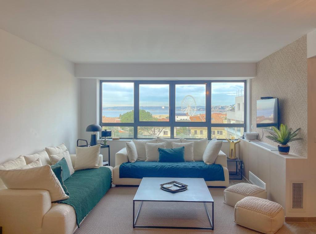 a living room with a couch and a large window at L’Escale Borely in Marseille